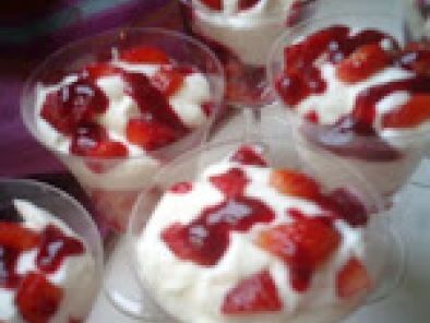 Mousse de yaourt sur lit de fraises et coulis de framboises.