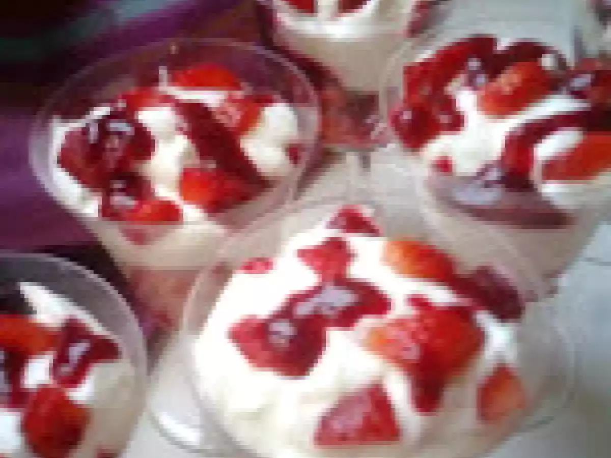 Mousse de yaourt sur lit de fraises et coulis de framboises.