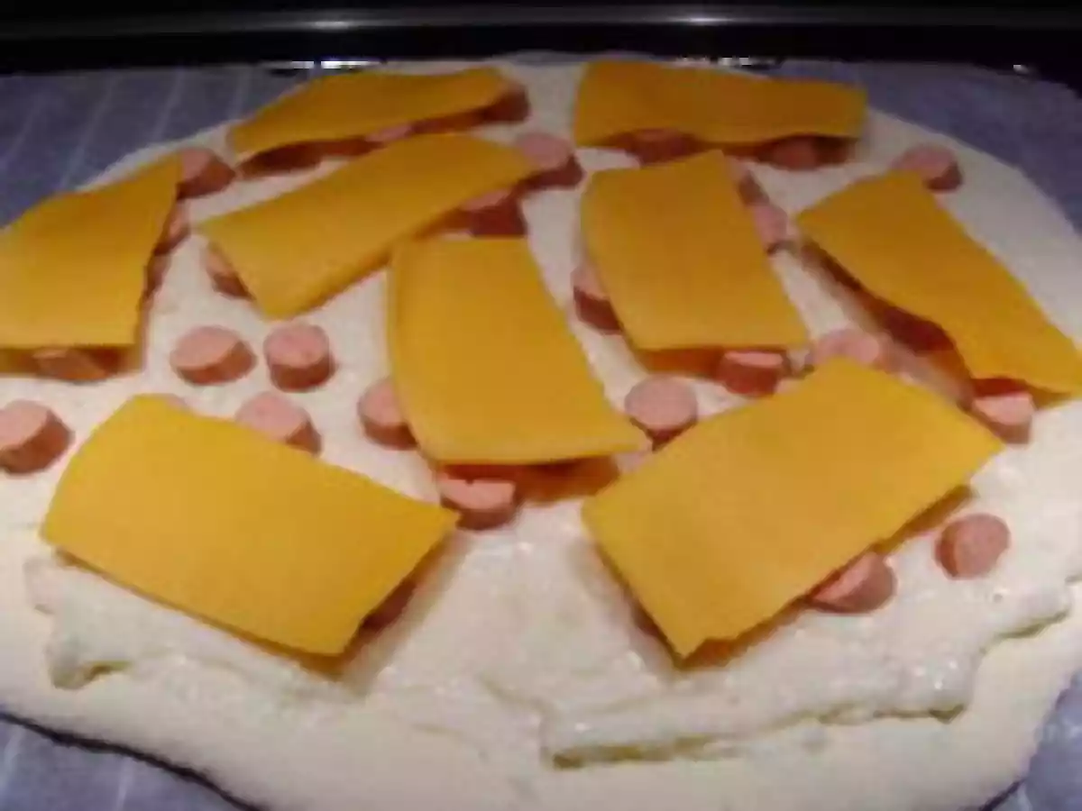 Pizza aux knacks, cheddar et béchamel.