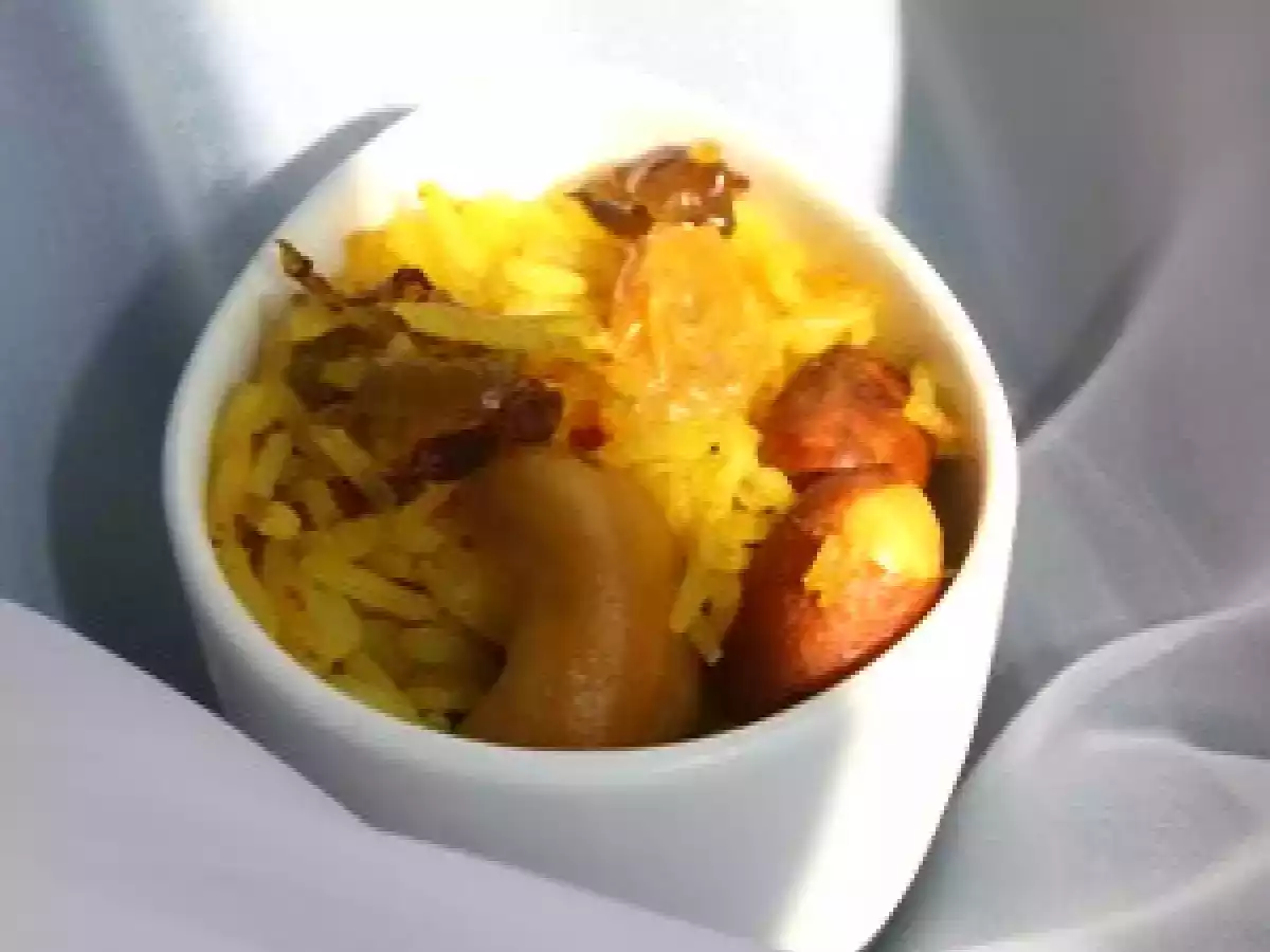Riz sauté au curcuma, oignons rouges, raisins secs et noix de cajou