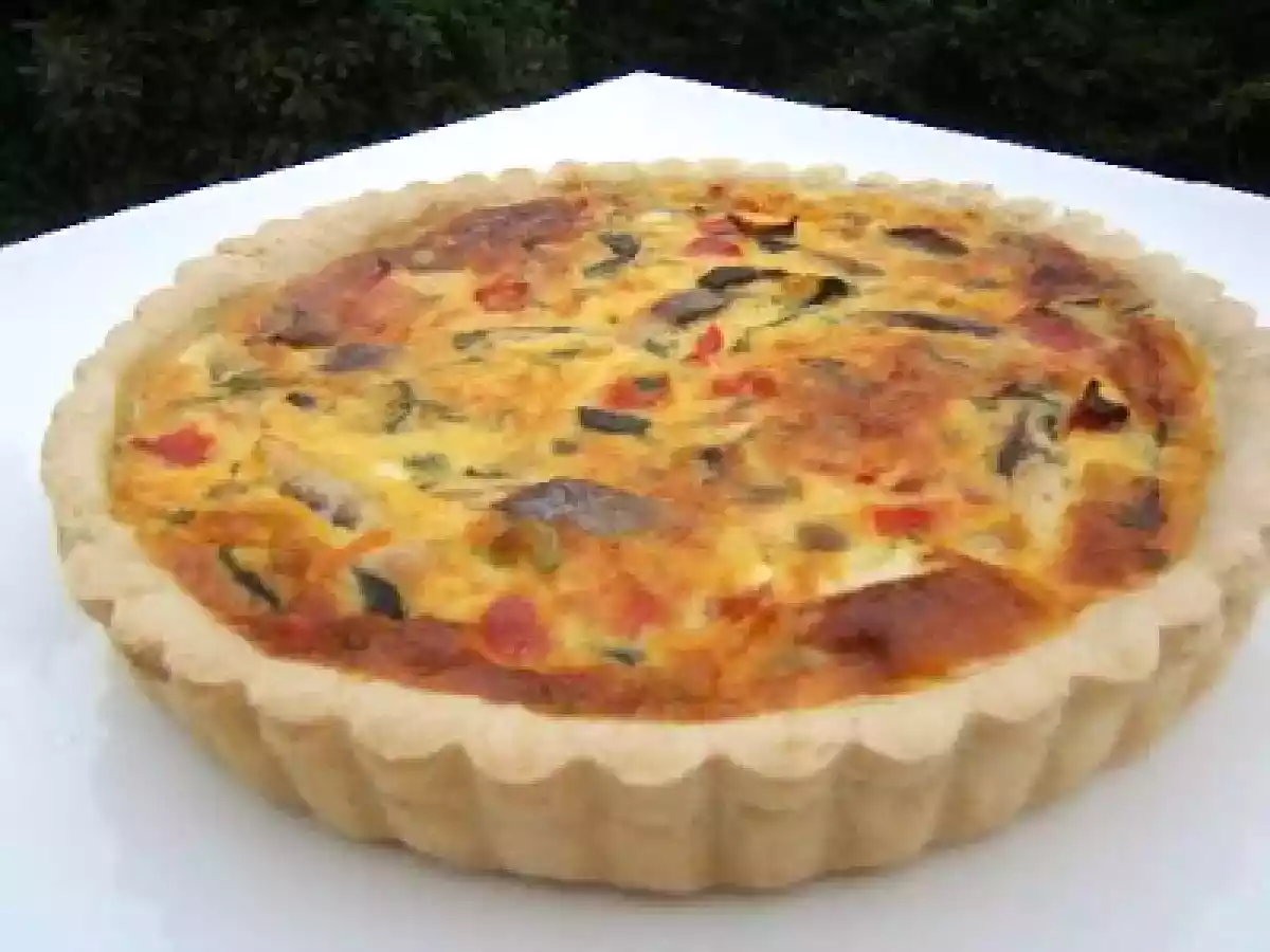 Tarte aux légumes rissolés et hareng fûmé sur une pâte brisée au cumin